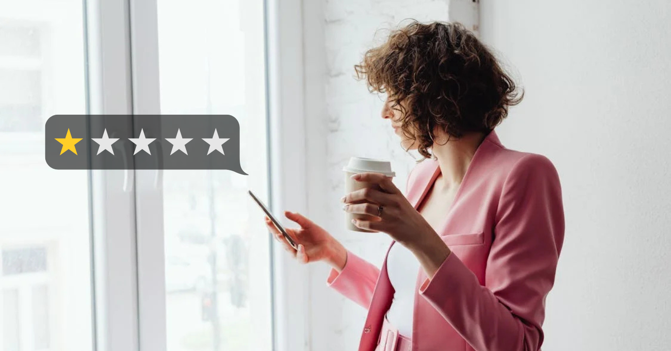 Woman looking at her phone with a one-star bad review, illustrating the challenge of handling negative feedback for businesses.